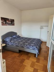 een slaapkamer met een bed en een houten vloer bij Tesa in Novi Beograd