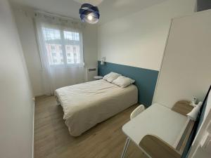 - une chambre avec un lit, une table et un miroir dans l'établissement Appartement 3 chambres - Proche Dock 76 - 128, à Rouen