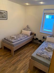 ランゲスハイムにある2-Zimmer-Wohung Langelsheim Astfeldのベッドが2つと窓のある部屋