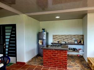 eine Küche mit einem Herd und einem Kühlschrank in der Unterkunft Casa Campestre Villa Maria in San José del Guaviare
