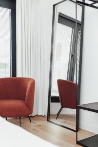 een spiegel en een stoel in een kamer bij CH Longstay 33 in Kortrijk