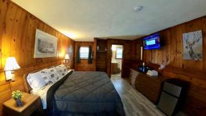 a bedroom with a bed and a flat screen tv at Heart of the Berkshires Motel in Pittsfield