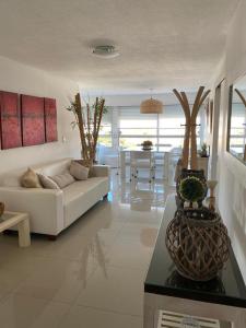 ein Wohnzimmer mit einem weißen Sofa und einem Tisch in der Unterkunft Apartamento Van Gogh Dpto 306 in Punta del Este
