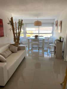 ein Wohnzimmer mit einem weißen Sofa und einem Tisch in der Unterkunft Apartamento Van Gogh Dpto 306 in Punta del Este