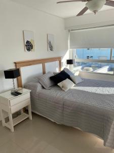 ein Schlafzimmer mit einem Bett und einem Tisch mit einer Lampe in der Unterkunft Apartamento Van Gogh Dpto 306 in Punta del Este