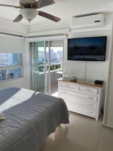 a bedroom with a bed and a flat screen tv at Apartamento Van Gogh Dpto 306 in Punta del Este