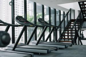 a row of treadmills in a gym with stairs at NEW Infinity Pool 3 Bedrooms 2 Carparks in Jelutong