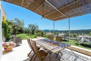 a patio with a table and chairs and a view at Mas De La Coste in Fayence