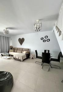 uma sala de estar com um sofá e uma mesa em Lovely Villa Sanmar, heated pool em Playa Blanca