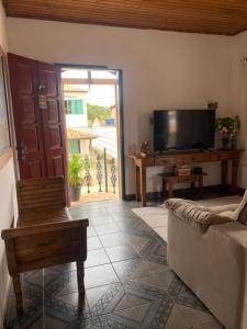 - un salon avec un canapé et une télévision dans l'établissement Casa Vista para Serra, à Tiradentes