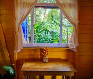 una finestra in una stanza con un tavolo di fronte di True Nature Jungle House a Bastimentos