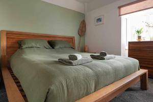 een slaapkamer met een groot bed en handdoeken bij Kingsgate Bay Bungalow - 950meter to Beach Dog friendly in Kent