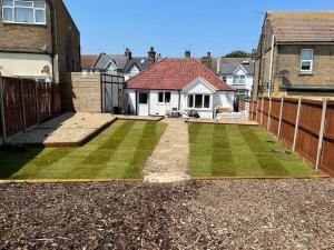 a yard with a fence and a house at Beach Retreat Cottage- huge Garden Child & Dog friendly in Broadstairs