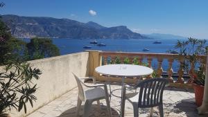 a table and chairs on a balcony with a view of the water at Hôtel de Charme Brise Marine in Saint-Jean-Cap-Ferrat