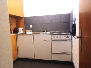 a kitchen with a stove and a sink at Allod Bad 504 in St. Moritz