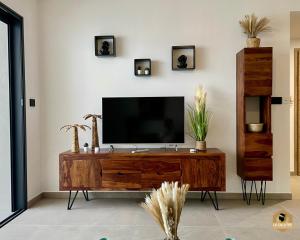 a living room with a television on a wooden entertainment center at Le Galatée Porticcio in Porticcio