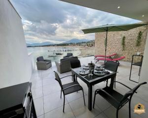 a patio with a table with chairs and an umbrella at Le Galatée Porticcio in Porticcio