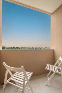2 sillas sentadas en un balcón con una gran ventana en Sunny Cozy Flat w/ Terrace - São João en Oporto
