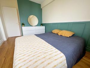 een slaapkamer met een groot bed en een spiegel bij Le Bleu Colbert in Versailles
