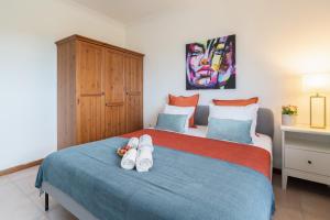 Un dormitorio con una cama con zapatos blancos. en Sunny Cozy Flat w/ Terrace - São João en Oporto