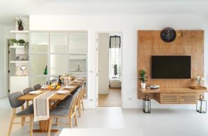 une salle à manger avec une grande table et une télévision dans l'établissement Kamala Garden View Villa 3 Bdr, à Kamala Beach