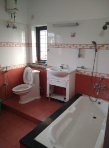 łazienka z wanną, toaletą i umywalką w obiekcie ECR Holiday w mieście Ćennaj