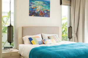 een slaapkamer met een bed met een schilderij aan de muur bij Kamala Garden View Villa 3 Bdr in Kamala Beach