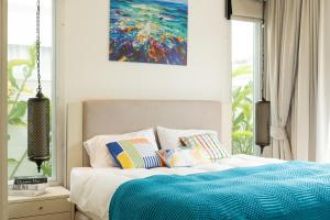 une chambre avec un lit avec un tableau sur le mur dans l'établissement Kamala Garden View Villa 3 Bdr, à Kamala Beach