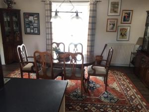 a dining room with a table and chairs on a rug at Sourdevalle 