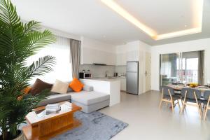 un salon avec un canapé et une table et une cuisine dans l'établissement Kamala Garden View Villa 3 Bdr, à Kamala Beach