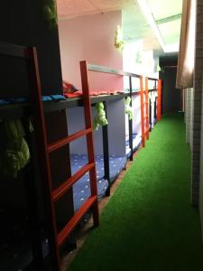 a row of bunk beds in a room with green carpet at Can Tho Riverside Hostel in Bình Thủy