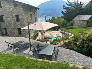 a table and chairs with an umbrella next to a building at L'antica Lodge in Cremia