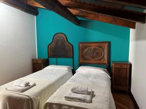 two beds in a room with a blue wall at L'antica Lodge in Cremia