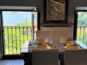 a dining room table with chairs and a table with wine glasses at L'antica Lodge in Cremia