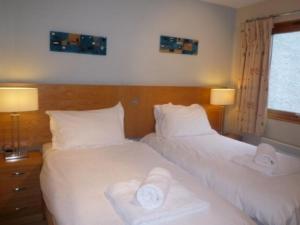 two beds in a hotel room with towels on them at Keswick Bridge 17 in Keswick