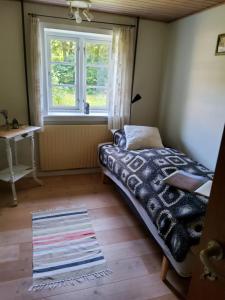 a bedroom with a bed and a window and a rug at Ringkøbing Fjord B&B in Skjern