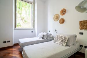 2 camas en una habitación blanca con ventana en Casa Bea - Art and Prestige, en Bérgamo