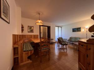 uma sala de estar com uma mesa de madeira e cadeiras em Trilocale Rendena 035 em Giustino
