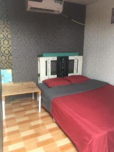 1 dormitorio con cama y mesa de madera en Can Tho Riverside Hostel, en Bình Thủy