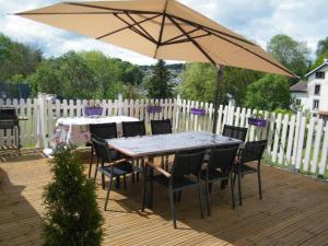 einen Tisch und Stühle unter einem Schirm auf einer Terrasse in der Unterkunft Chez Laurent et Sandrine in Chantraine