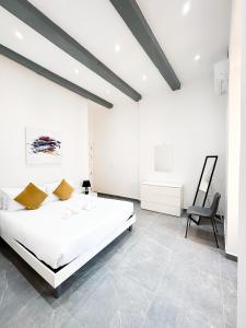 1 dormitorio blanco con 1 cama grande y 1 silla en Valletta Waterfront Backyard Flat, en Floriana