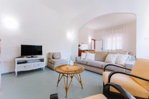 ein Wohnzimmer mit einem Sofa und einem TV in der Unterkunft Casa Daniela in Terra Mala