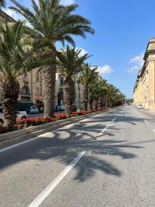 a street with palm trees on the side of a road at Valletta Waterfront Backyard Flat by Arco Collection in Il-Furjana