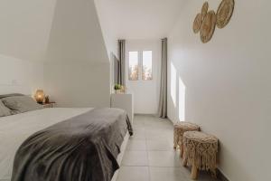 a white bedroom with a bed and two stools at SUPER Oldtown in Funchal