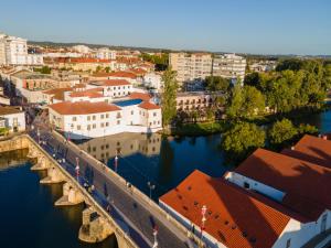 eine Stadt mit einer Brücke über einen Fluss mit Gebäuden in der Unterkunft Vila Gale Collection Tomar in Tomar
