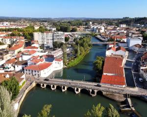 eine Luftansicht auf eine Stadt mit einer Brücke und einem Fluss in der Unterkunft Vila Gale Collection Tomar in Tomar