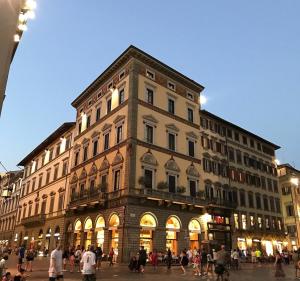 un grand bâtiment avec des personnes qui marchent devant lui dans l'établissement Palazzo Gamba Apartments al Duomo, à Florence