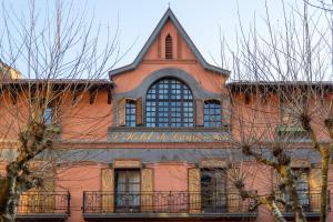 un grand bâtiment orange avec une horloge. dans l'établissement Hotel de Camprodón, à Camprodon