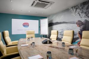 a conference room with a table and chairs and a screen at Langstone Quays Resort in Havant