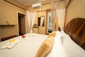 Schlafzimmer mit einem Bett mit weißer Bettwäsche und einem Fenster in der Unterkunft Navona Apartment in Rom
